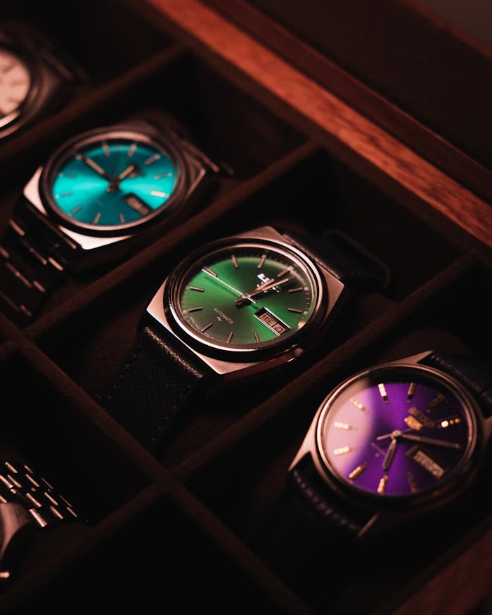 why-choose-us Showcase of vintage wristwatches in a wooden box with colorful dials.